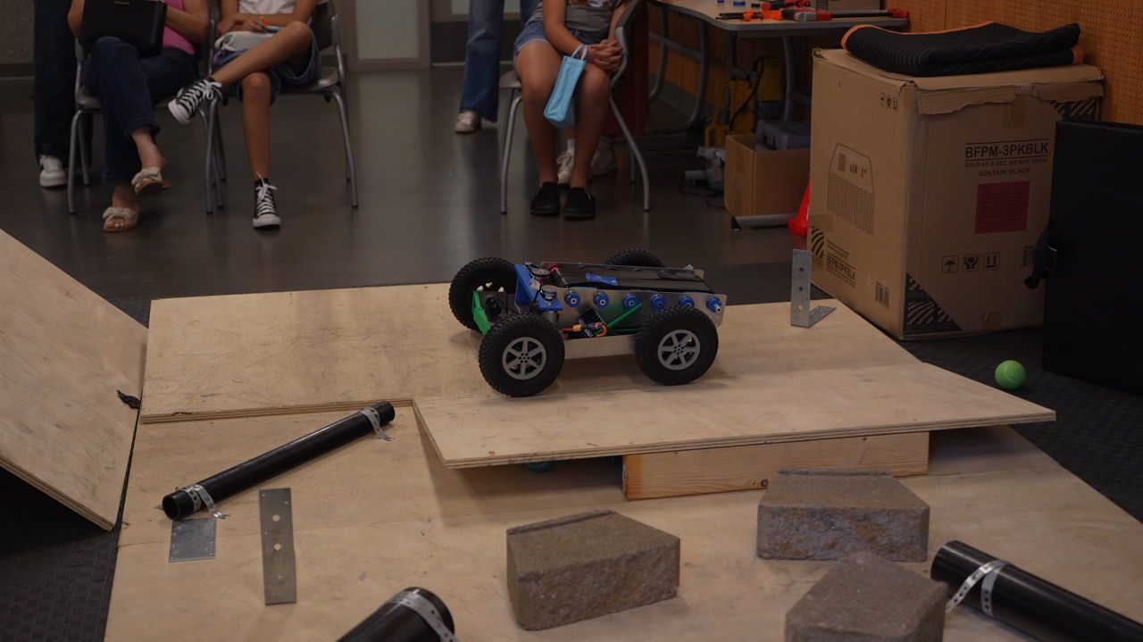 A student robot climbing the plywood ramp
